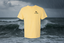Load image into Gallery viewer, Yellow t-shirt with a black Lucky Labrador logo on the chest against a stormy ocean background