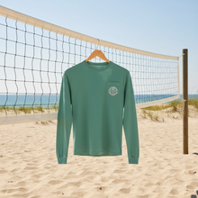 Load image into Gallery viewer, Green long-sleeve shirt with a Lucky Labrador logo near a beach volley ball net