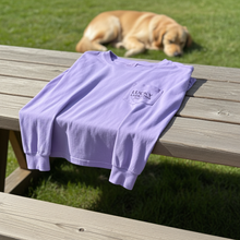 Load image into Gallery viewer, Purple long-sleeve shirt with a l Lucky Labrador logo on a wooden bench with a dog in the background